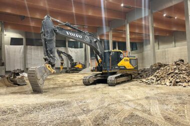 2 Bagger in der Halle, dahinter Steinhaufen